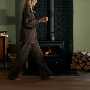 girl walking by fire holding a mug