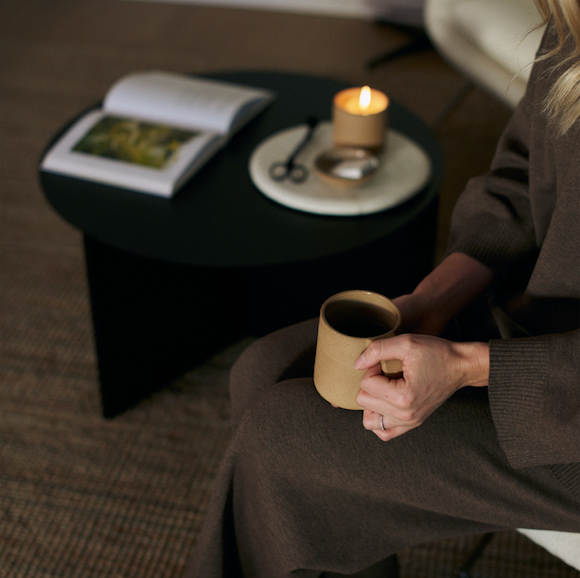 girl holding ceramic mug while sitting